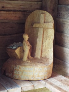 Wooden sculpture depicting  the stony hearts left at the cross.